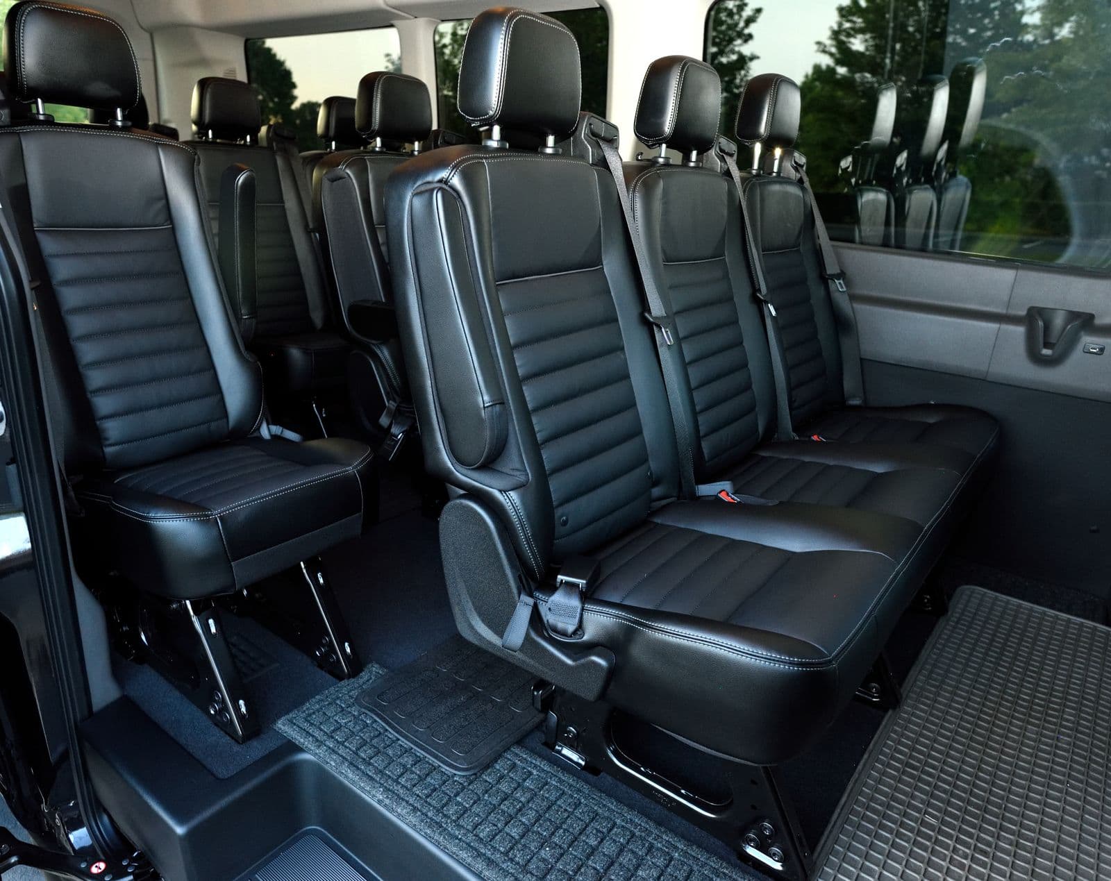 Black leather passenger seats in three rows inside a premium people mover